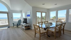 A spacious room with a large dining table, chairs, a television, and a view of the beach. - 3 bedroom accommodation in Holgate (Holgate)