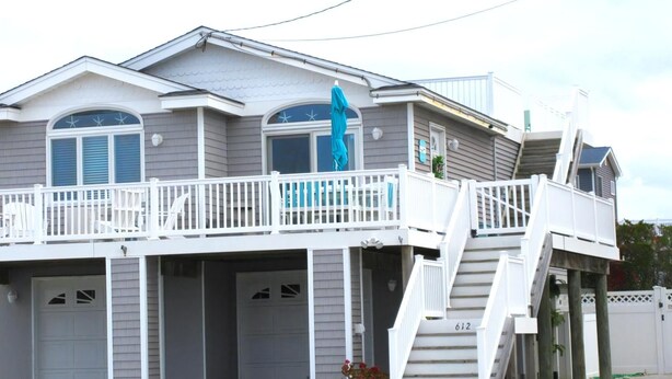 Une maison à deux étages avec un balcon, un escalier et un garage.