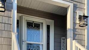 A house with a number 9 sign, a white door with a glass panel, and a 'WELCOME' sign on the wall. - Ocean views- luxurious vacation rental on LBI (Brant Beach)