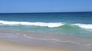 Ein Strand mit Wellen und blauem Himmel.