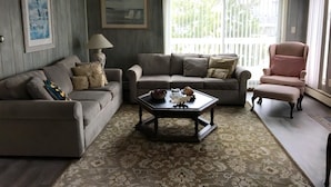 A living room with a sofa, armchair, and coffee table.