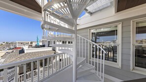 A white spiral staircase with a clear view of the surrounding area, including a balcony with a view of the beach and other buildings. - Nice home in Ship Bottom with 3 Bedrooms, Private swimming pool and WiFi (Ship Bottom)