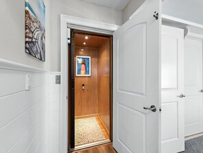 A hallway with a wooden door leading to a room, a framed picture on the wall, and a patterned rug on the floor. - Nice home in Ship Bottom with 3 Bedrooms, Private swimming pool and WiFi (Ship Bottom)