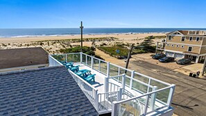 A balcony with blue chairs overlooking a beach and ocean. - Nice home in Ship Bottom with 3 Bedrooms, Private swimming pool and WiFi (Ship Bottom)