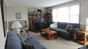 A living room with a sofa, armchair, coffee table, fireplace, and a window with blinds. - Stunning home in Ship Bottom with 4 Bedrooms and Internet (Ship Bottom)