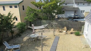 A backyard with a hammock, chairs, and a small table. - Stunning home in Ship Bottom with 4 Bedrooms and Internet (Ship Bottom)