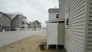 A residential area with a fenced yard, a small shed, and houses with similar architecture. - Outstanding Bayviews from this 1st floor duplex (Surf City)