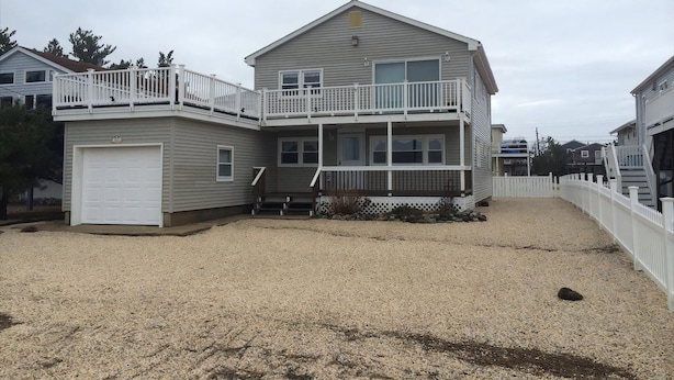 A two-story house with a front deck and a garage. - Outstanding Bayviews from this 1st floor duplex (Surf City)