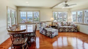 A spacious living room with a dining table, chairs, a sofa, and a ceiling fan. - North Beach Townhouse (North Beach)