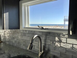 Una cocina con ventana que da a la playa.