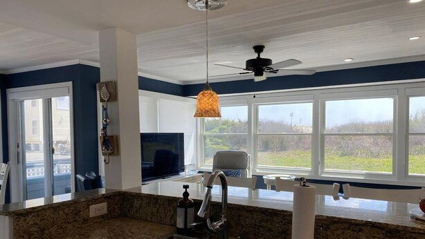 A modern kitchen with granite countertops, a stainless steel sink, and a ceiling fan. - 2 bedroom 2 bath ocean front condo with pool in Ship Bottom first floor unit (Ship Bottom)