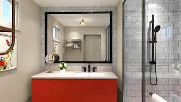 A modern bathroom with a large mirror, a shower, and a red vanity.