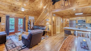 Un interior acogedor de cabaña con sala de estar, comedor y cocina.