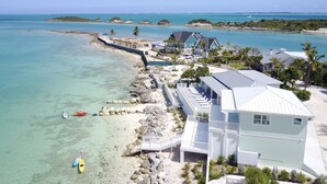 A coastal property with a beach, a pier, and several houses.