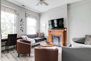 A modern living room with a fireplace, a television, and comfortable seating.