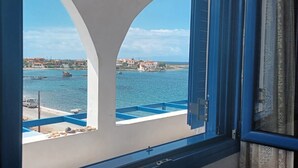 A balcony with a view of a coastal town and the sea.