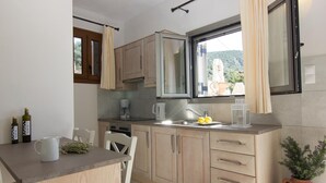 Une cuisine moderne avec des meubles en bois, un four encastré et une fenêtre avec des rideaux.