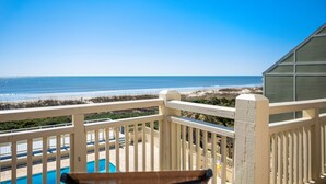 Un balcon avec vue sur la plage et l’océan.