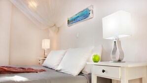 Una habitación de hotel ordenada con una cama, una mesita de noche con una lámpara y una manzana verde sobre la mesa.