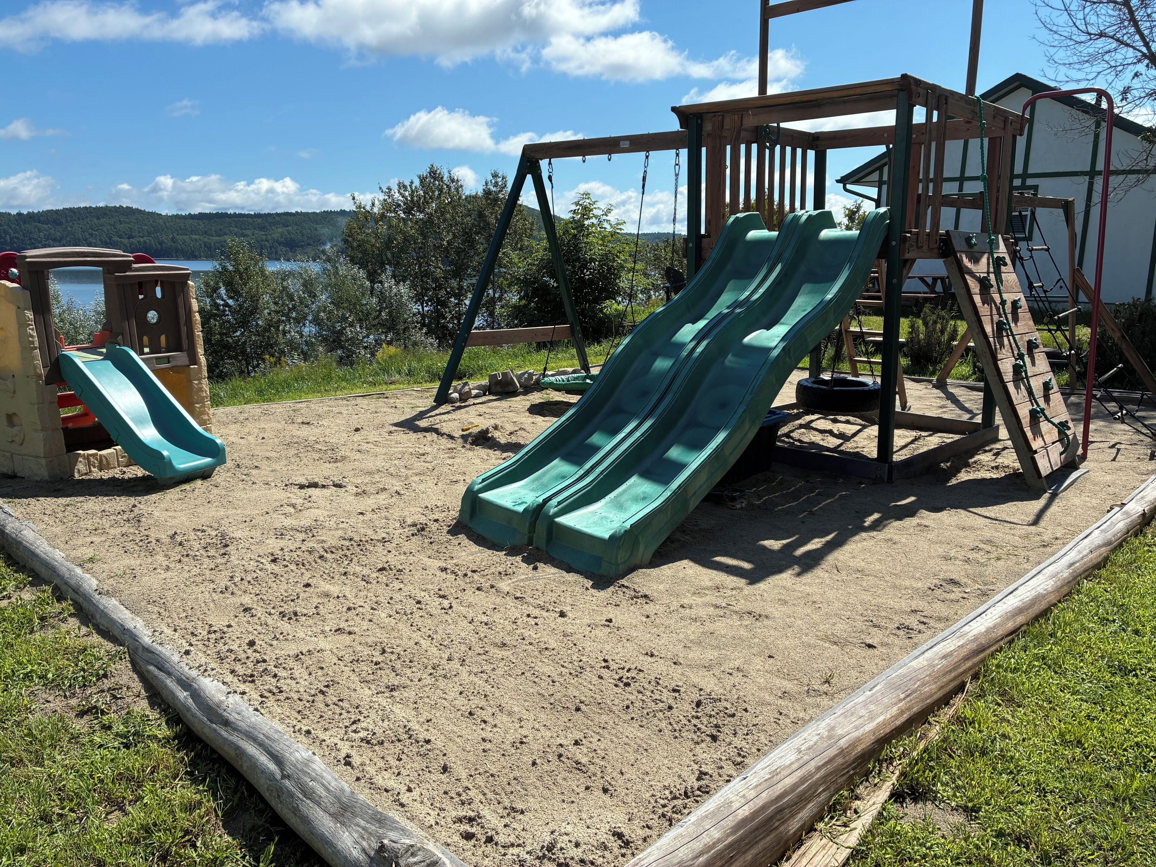 A playground with two slides and a climbing structure.