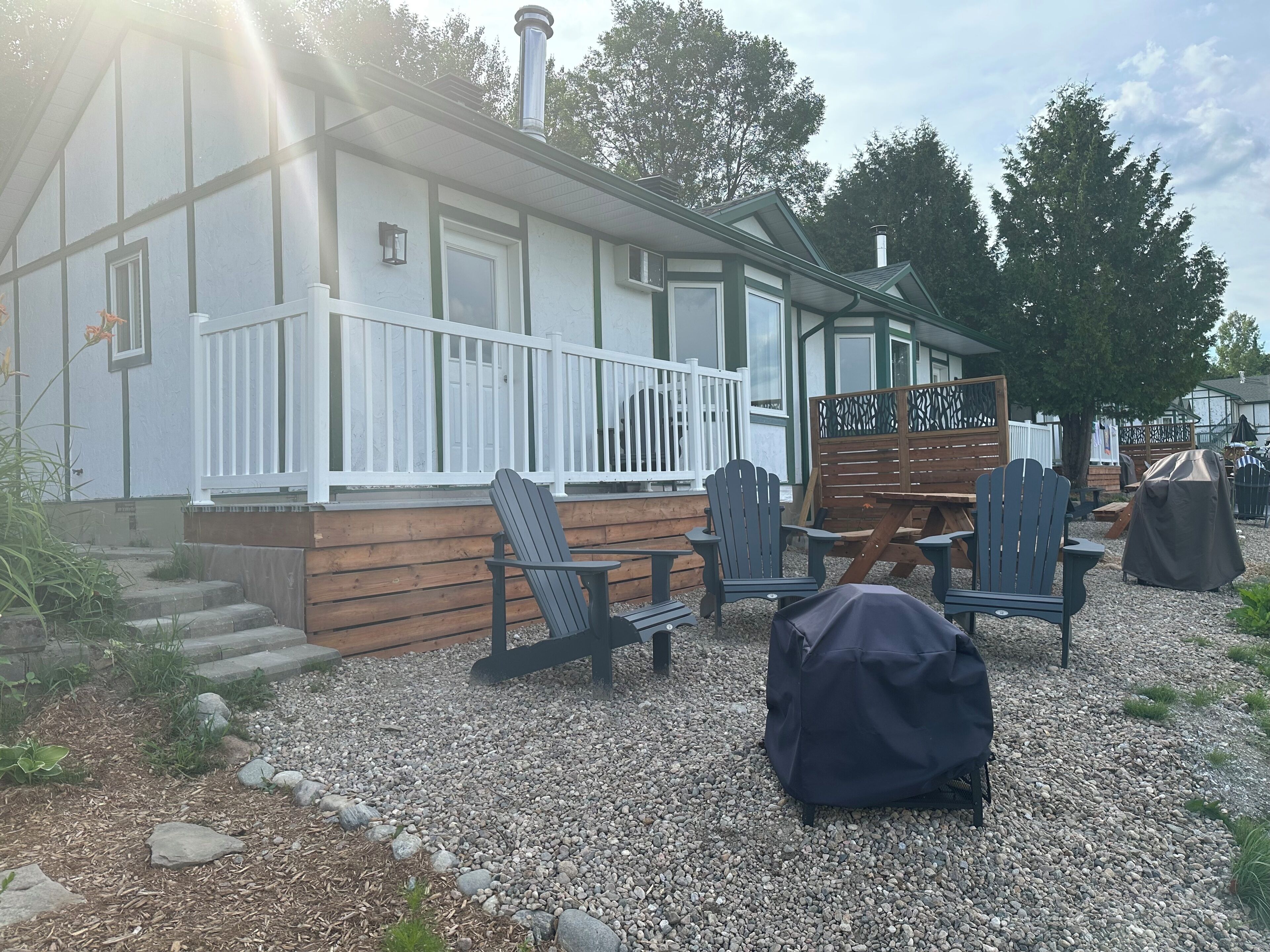 A building with a porch, outdoor seating, and a covered barbecue area.