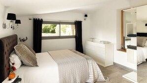 A bedroom with a bed, bedside table, dresser, and a window with curtains. - Villa Bonifacio Les Maquisardes (Bonifacio)