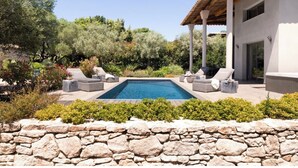 A modern house with a swimming pool, stone wall, and outdoor seating area. - Villa Bonifacio Les Maquisardes (Bonifacio)