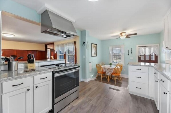 Enjoy cooking in the well-equipped kitchen with a large stove, modern cabinetry, and granite countertop.