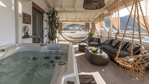 Un bain à remous, un hamac, un canapé et une vue sur la montagne.