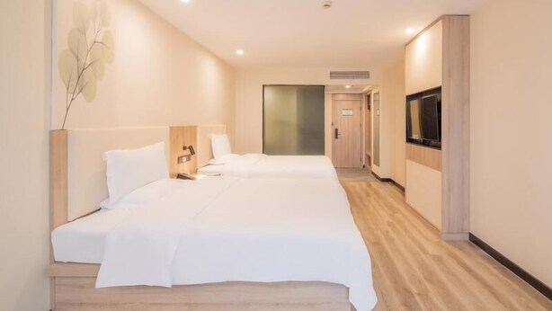 A hotel room with two beds, a TV, and a wooden floor. - Greentree Inn Nantong Jiaoyu Road Hotel (Nantong)