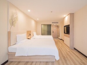 A hotel room with two beds, a TV, and a wooden floor. - Greentree Inn Nantong Jiaoyu Road Hotel (Nantong)