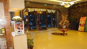 A lobby with a polished floor, a reception desk, a potted plant, and a glass door entrance. - Greentree Inn Nantong Jiaoyu Road Hotel (Nantong)