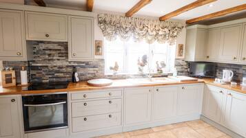 Cottage | Private kitchen | Fridge, electric kettle, toaster, cookware/dishes/utensils