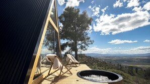 A wooden deck with two lounge chairs and a fire pit, overlooking a mountainous landscape. - TheVagar  (Belmonte)