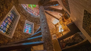Una escalera de piedra con barandillas de madera y vidrieras de colores.