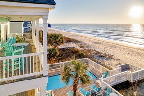 A balcony with a pool, chairs, and a view of the beach. - Salty Breeze: Luxury Oceanfront w/Private Pool, Hot Tub & Firepit (Murrells Inlet)