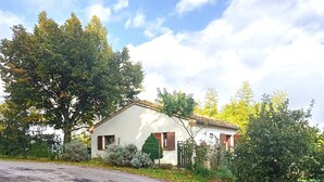 A white building with a tiled roof, surrounded by trees and shrubs. - Small cottage near the Sibillini Mountains (Marche)