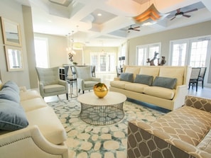 A spacious living room with a round coffee table, a beige sofa, and a patterned rug.