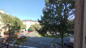 A street view with a building, trees, and parked cars. - Chez Michèle (Toul)