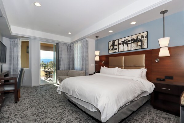 A hotel room with a large bed, a desk, and a view of the outdoors. - COACHELLA Marriott Desert Springs Villas 2, Kitchen, Access to Resort Amenities (Palm Desert)