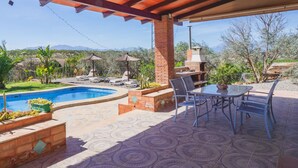 Eine Außenpatio mit Pool, Grillplatz und Sitzgruppe.