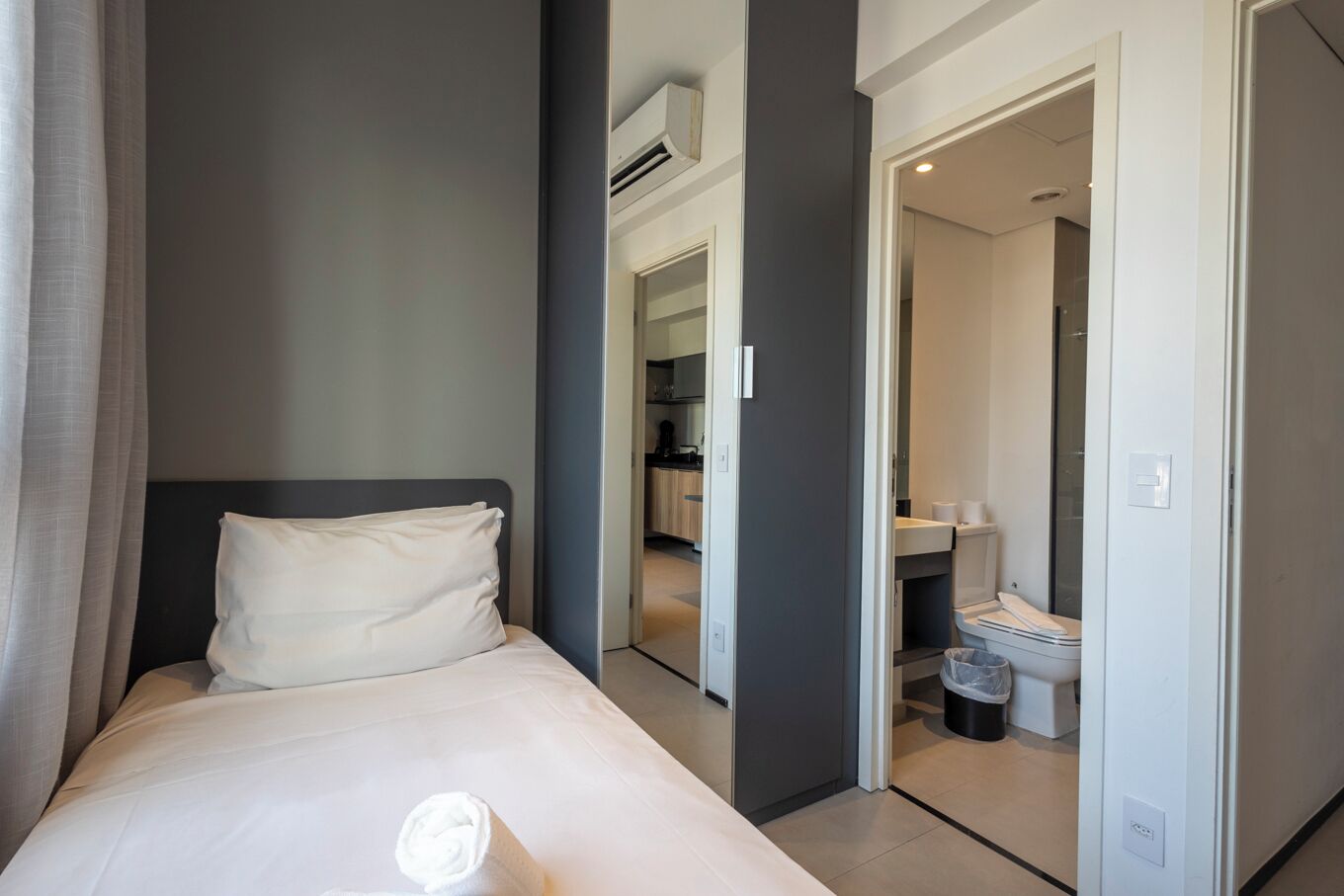 Ett hotellrum med en säng, ett badrum och ett litet kök.
