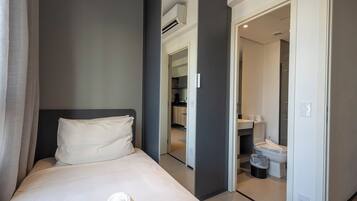 Ett hotellrum med en säng, ett badrum och ett litet kök.