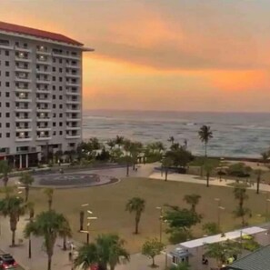 A hotel with a large building, a beach, and palm trees. - Condado King Studio | Steps to Beach + Views (San Juan)