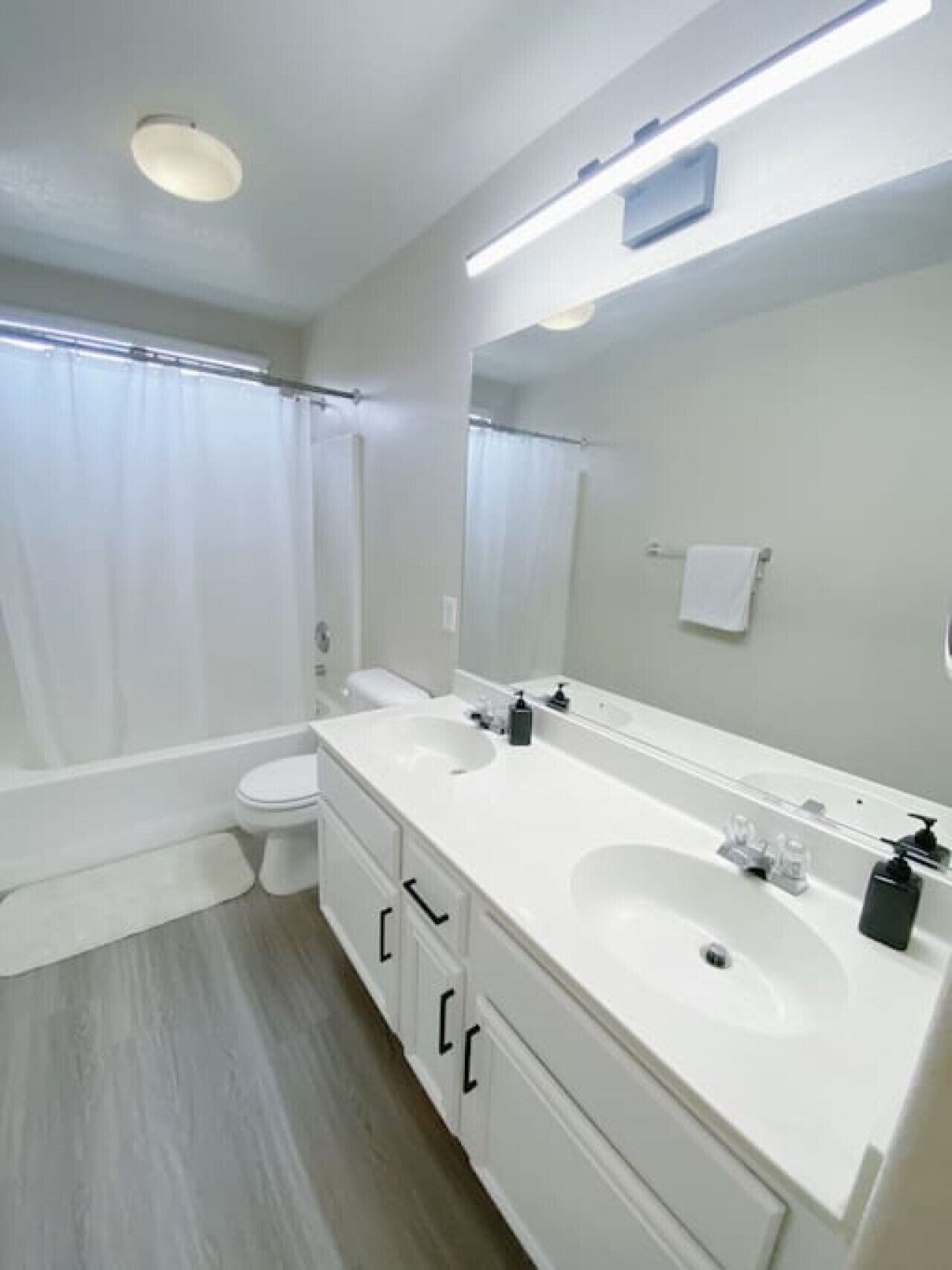 Un baño moderno con bañera, inodoro y tocador doble.