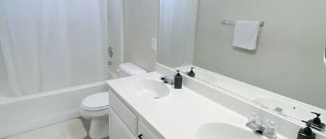Un baño moderno con bañera, inodoro y tocador doble.