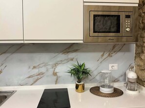 Een magnetron, een oven, een kookplaat, een koffiezetapparaat/waterkoker