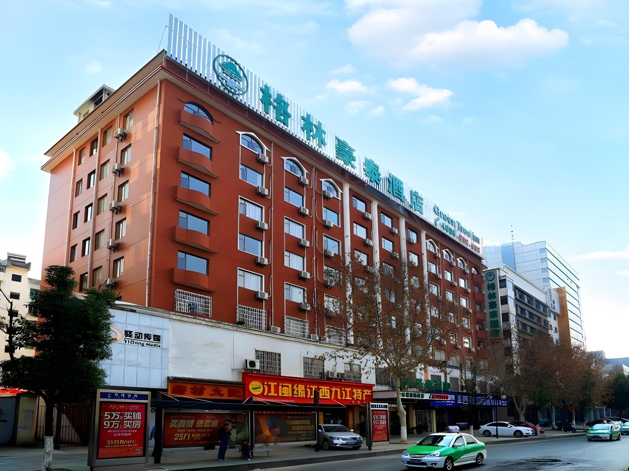 A multi-story hotel with a red facade, multiple balconies, and a sign indicating it is a hotel.