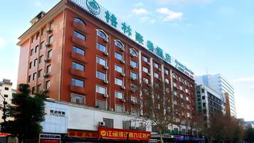 A multi-story hotel with a red facade, multiple balconies, and a sign indicating it is a hotel.
