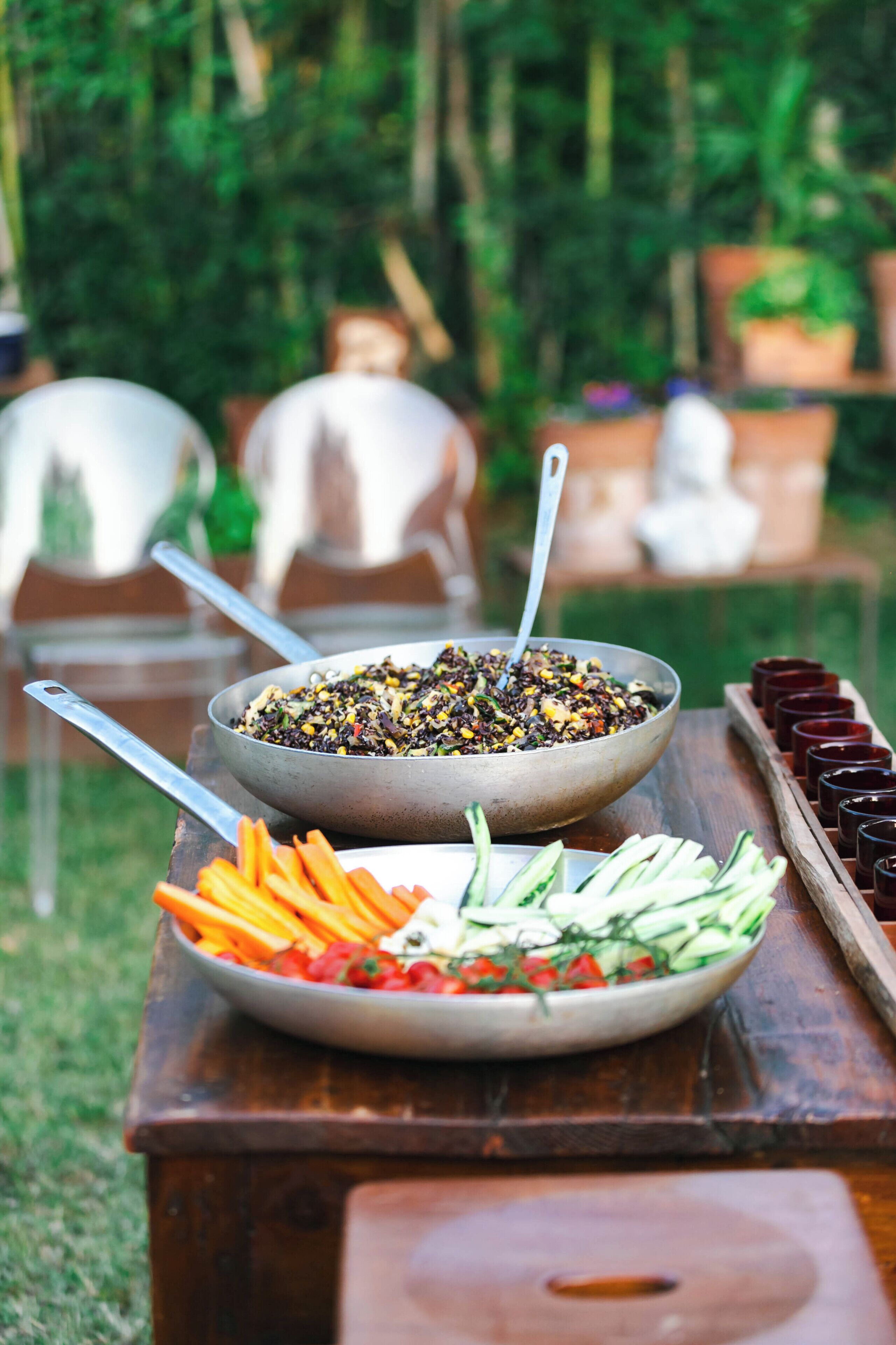 Une table à manger avec un saladier rempli de salade, un bol de céréales et un plateau de boissons.